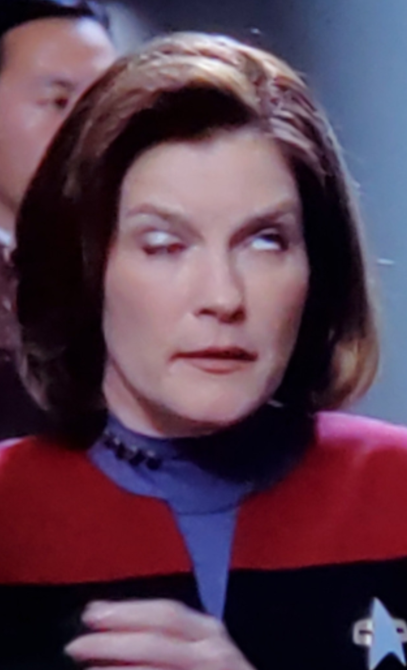 Janeway has one eye open looking straight up and one eye closed