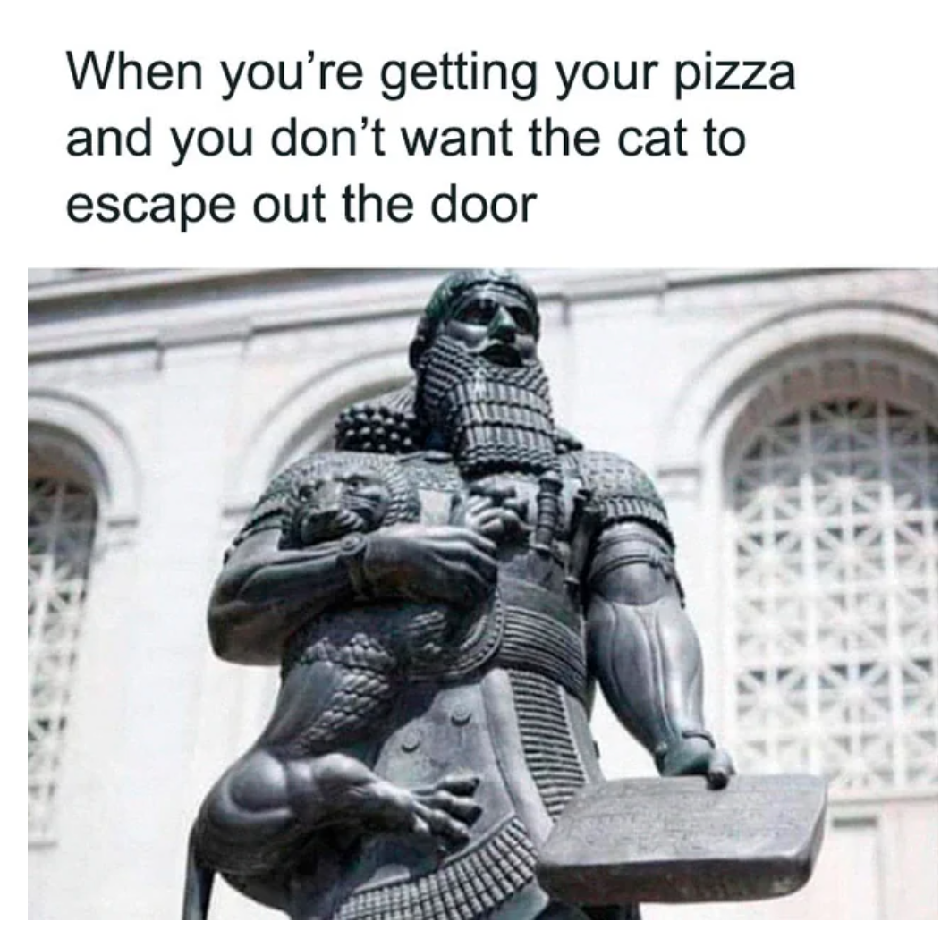 Antique statue of a warrior with a curly beard, holding a lion in one arm and probably a ceramic tablet in the other. There's a caption over the picture: "When you're getting your pizza and you don't want the cat to escape out the door"